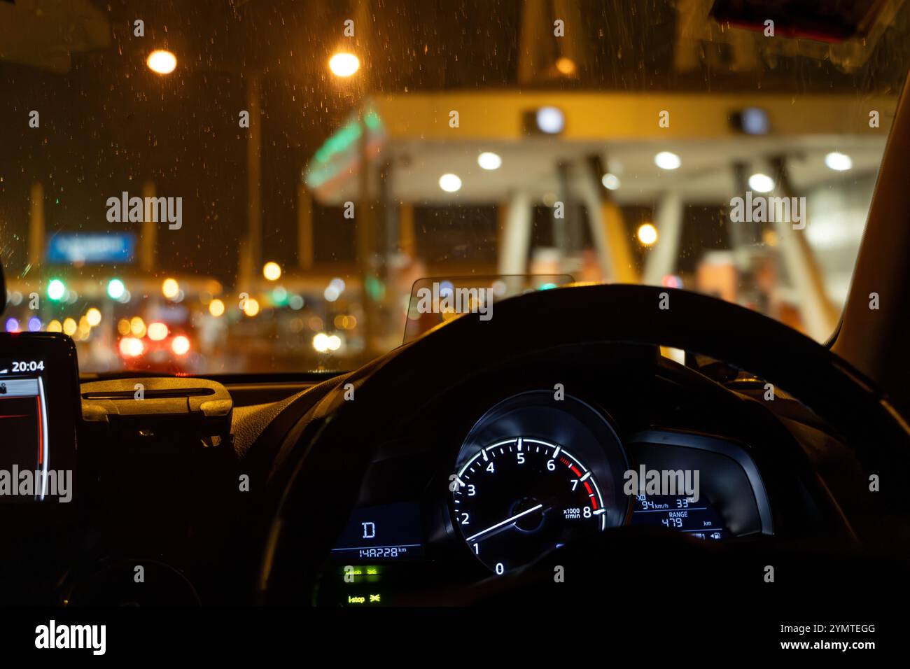 A car passes a toll gate on a highway at night Stock Photo