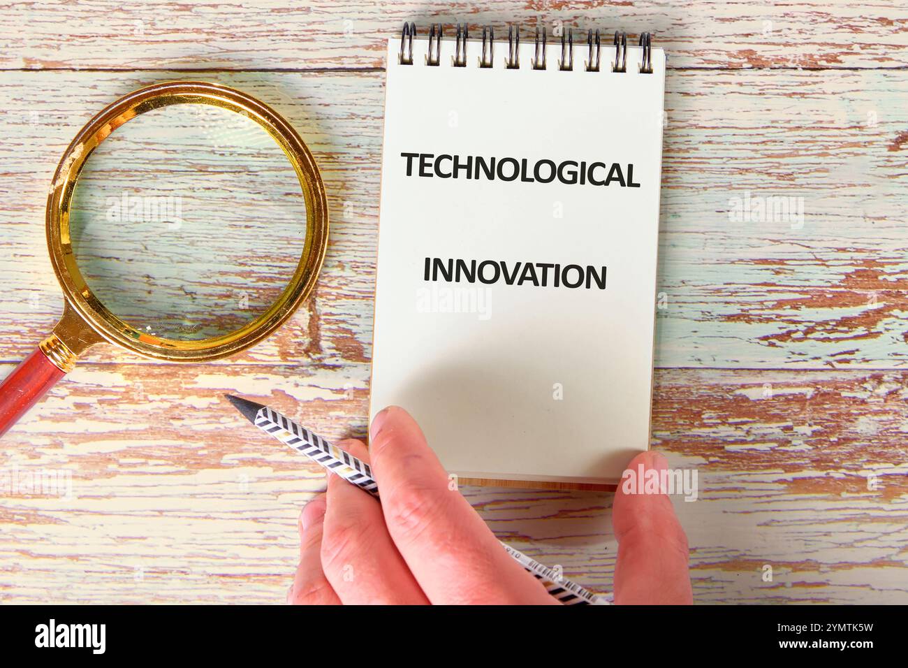 Business, programming, interface, application and network concept. Text TECHNOLOGICAL INNOVATION in a notebook against the background of old boards. Stock Photo