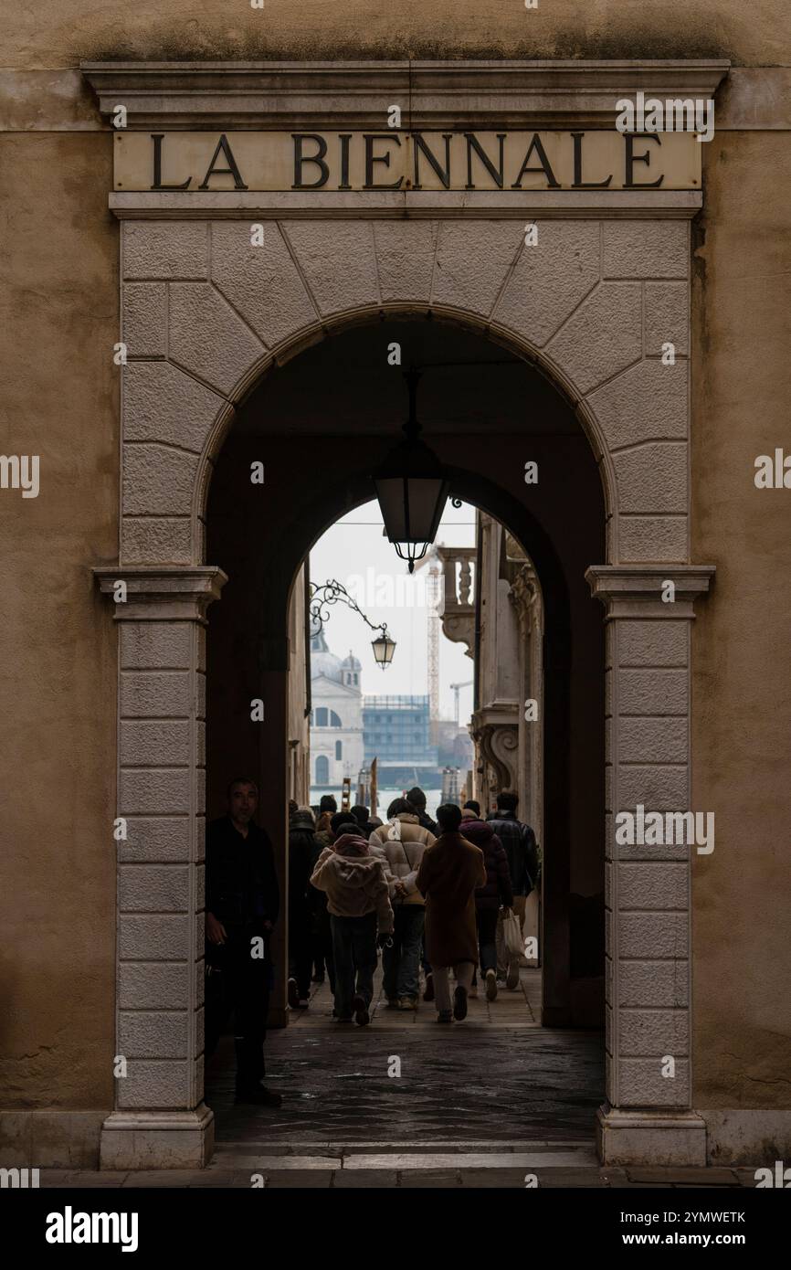 Tourists passing trough low arch entrance door to La Biennale in Venice, Italy 04.01.2024 Stock Photo