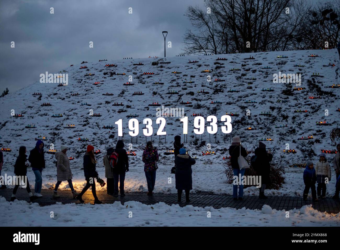 People seen looking towards a hill filled with lit candles on Holodomor ...