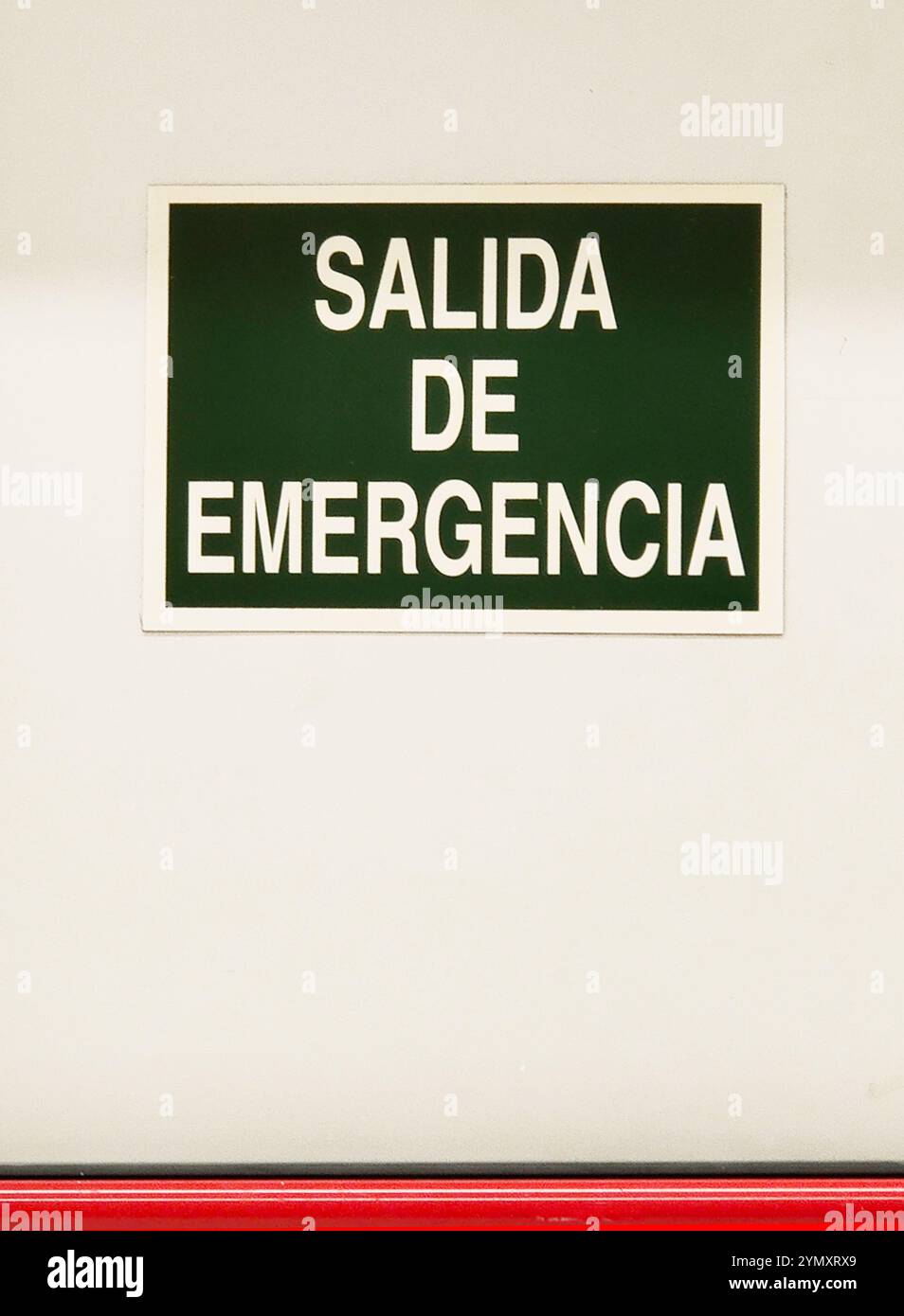 A green sign with white text reading ‘EMERGENCY EXIT’ to guide people ...