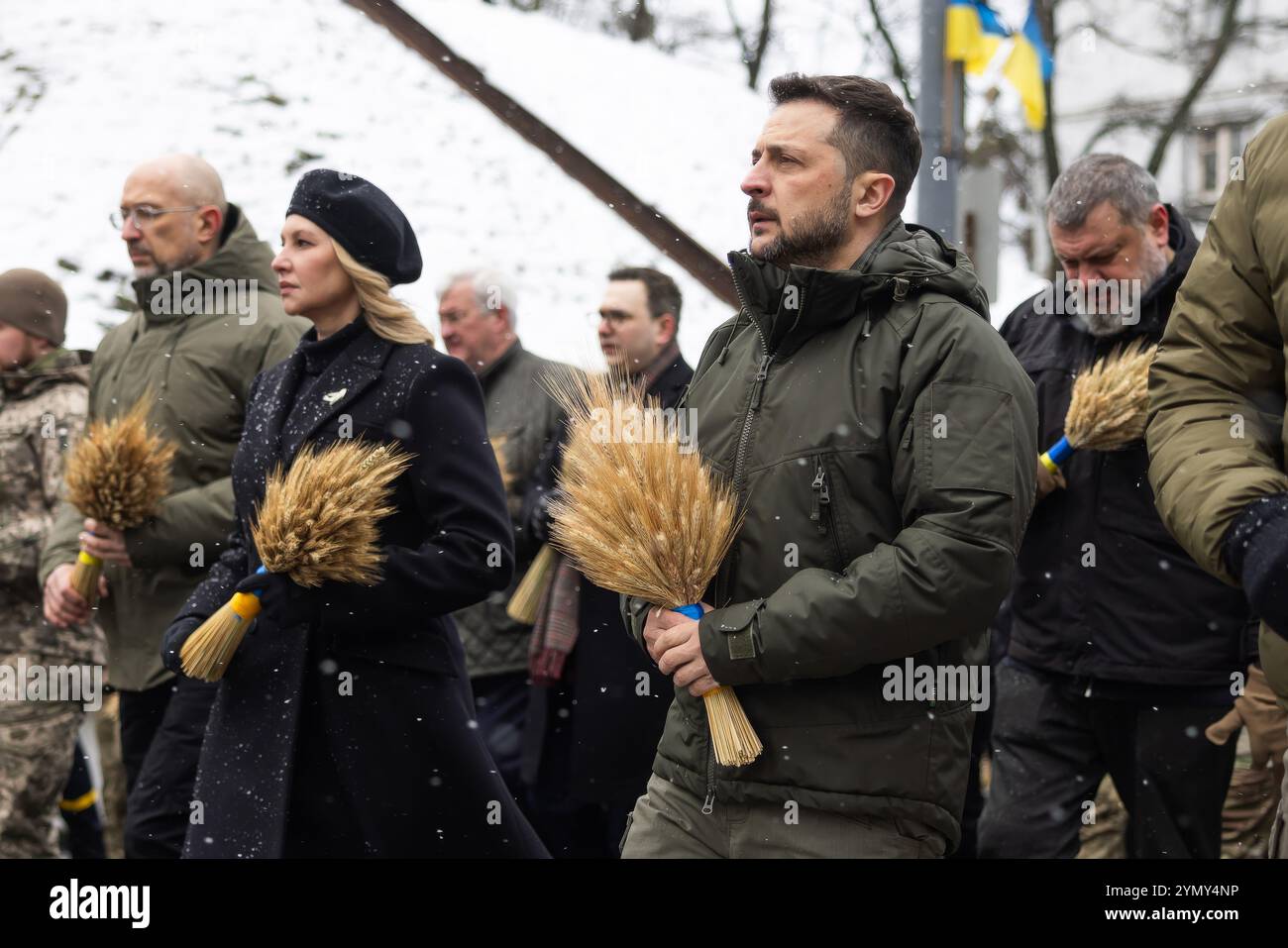 Kyiv, Ukraine. 23rd Nov, 2024. Ukrainian First Lady Olena Zelenska, left, and President Volodymyr Zelenskyy, right, stand for a moment of silence before placing wheat sheafs on the Bitter Memory of Childhood statue honoring the victims of the Holodomor famine on a snowy evening at the Pechersk Hills, November 23, 2024 in Kyiv, Ukraine. Ukraine marked the anniversary of mass starvation of Ukrainians by Stalin that killed 4 million people. Credit: Ukraine Presidency/Ukrainian Presidential Press Office/Alamy Live News Stock Photo