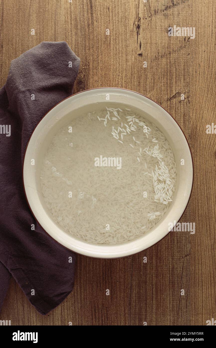 Ceramic bowl, with rice soaked in water, raw rice in water, top view ...