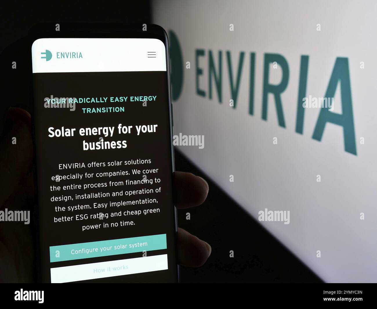 Stuttgart, Germany, 04-02-2024: Person holding mobile phone with web page of German solar company ENVIRIA Energy Holding GmbH in front of logo. Focus Stock Photo