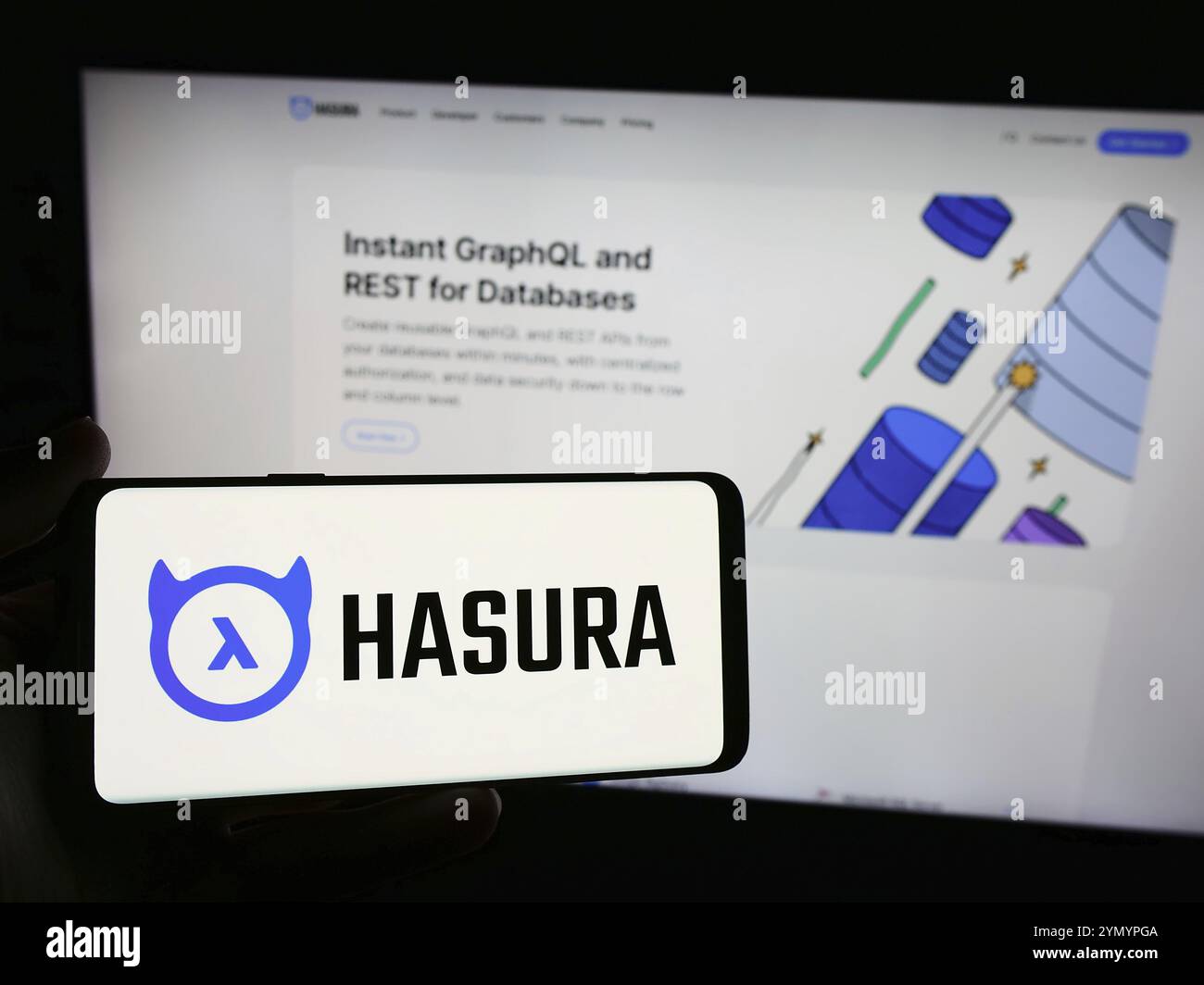 Stuttgart, Germany, 05-07-2024: Person holding smartphone with logo of US software development company Hasura Inc. in front of website. Focus on phone Stock Photo