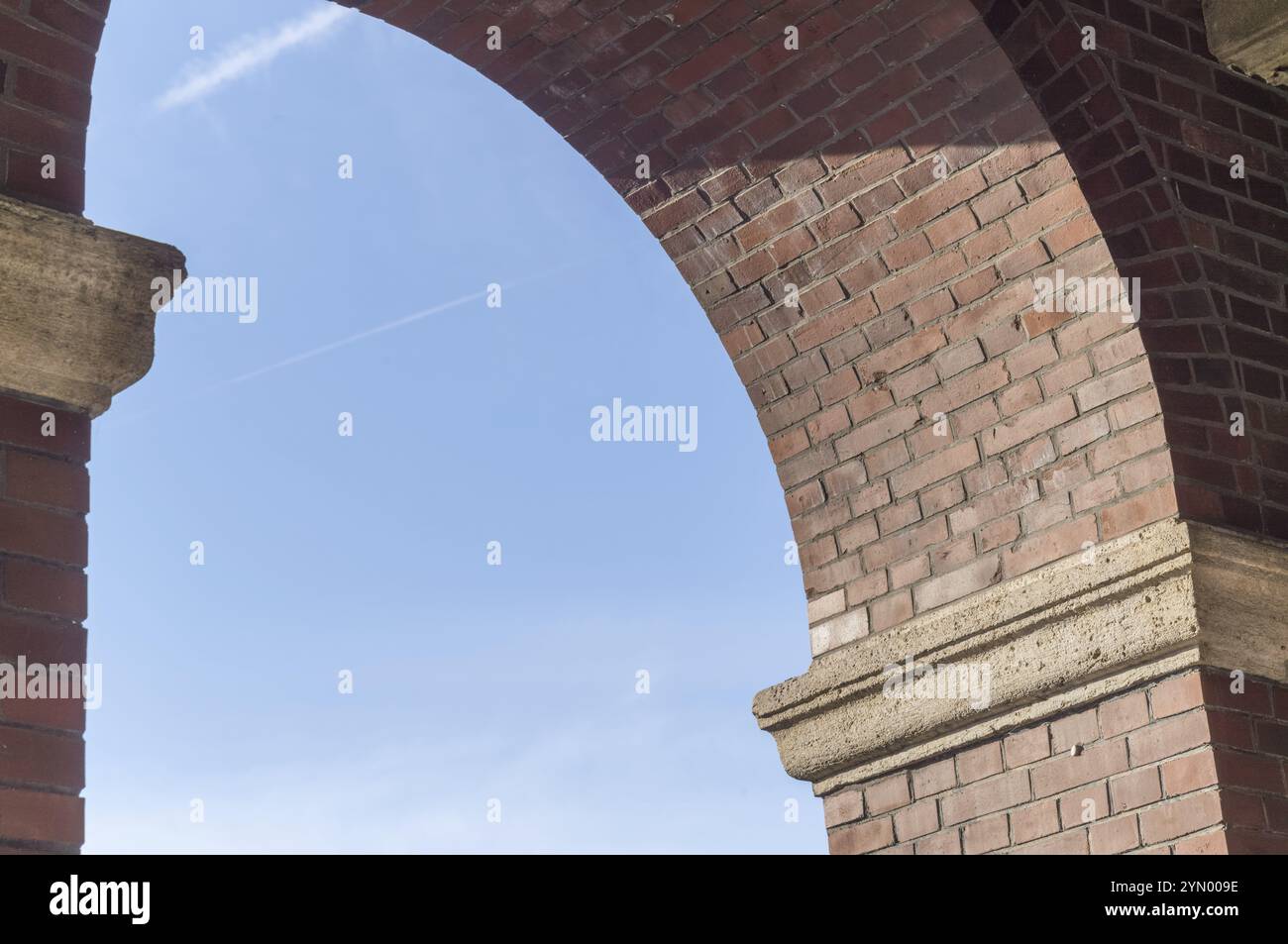 Blue sky seen through a brick arch of a building Stock Photo