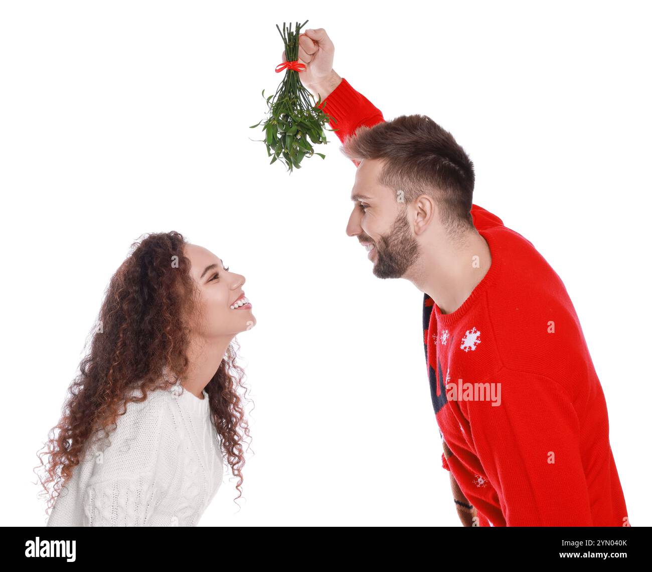 Lovely couple under mistletoe bunch on white background Stock Photo - Alamy