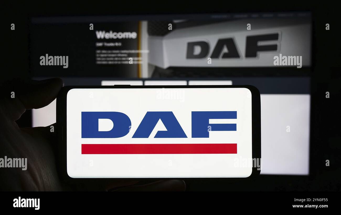 Stuttgart, Germany, 03-17-2024: Person holding cellphone with logo of Dutch truck manufacturing company DAF Trucks N.V. in front of business webpage. Stock Photo