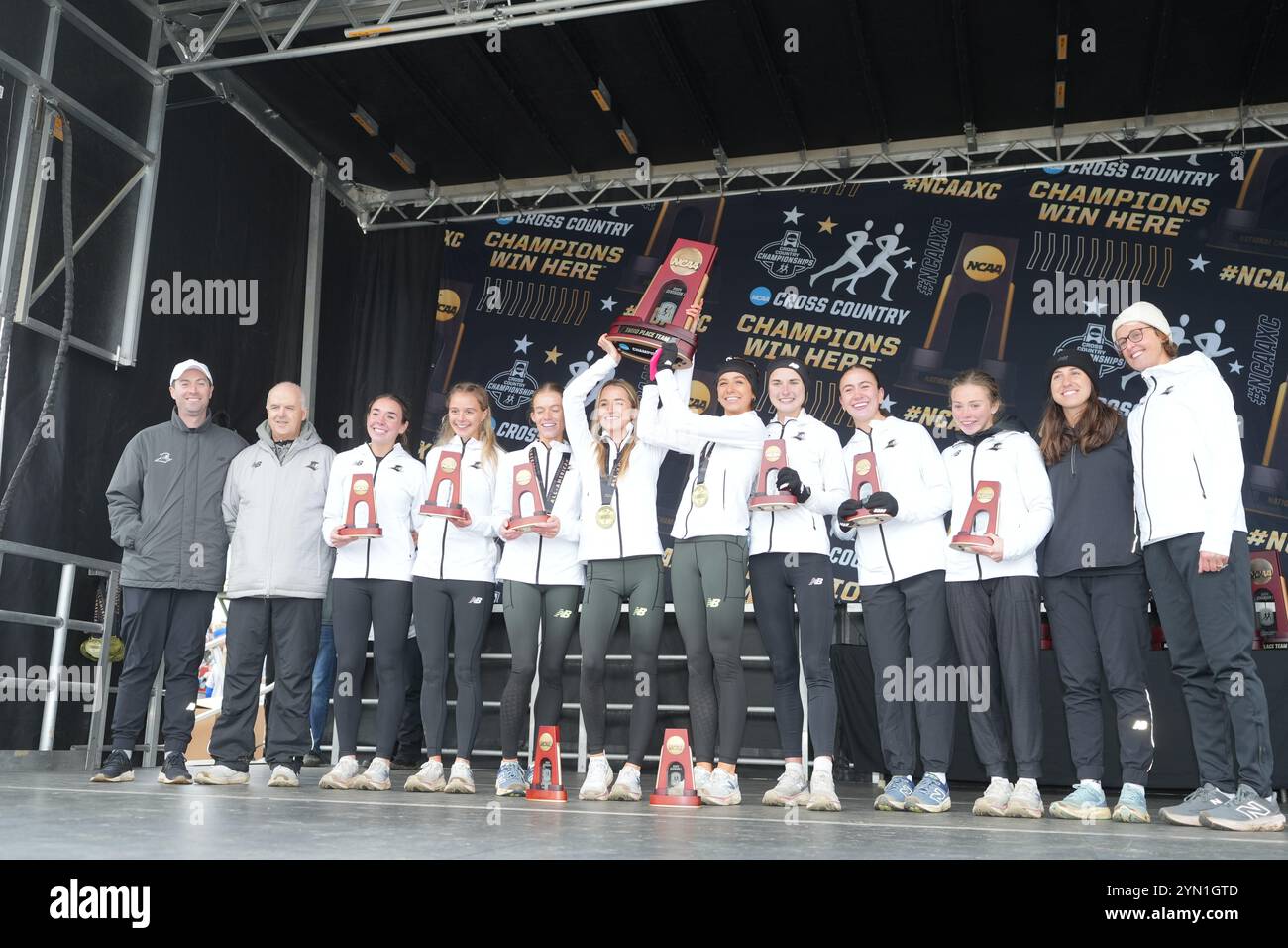 Madison, Wisconsin, USA. 23rd Nov 2024. The Providence Friars women's team including coach Ray Treacy, Emily Bush, Reese Fahys, Shannon Flockhart, Anna Gardiner, Kiera Hall, Claire Kelly, Cara Laverty, Kimberly May, Alex Millard, Laura Mooney and Niamh O'Mahony pose after placing third in the team standings during the NCAA cross country championships at the Thomas Zimmer Championship Course, Saturday, Nov. 23, 2024, in Madison, Wisc. Credit: Kirby Lee/Alamy Live News Stock Photo