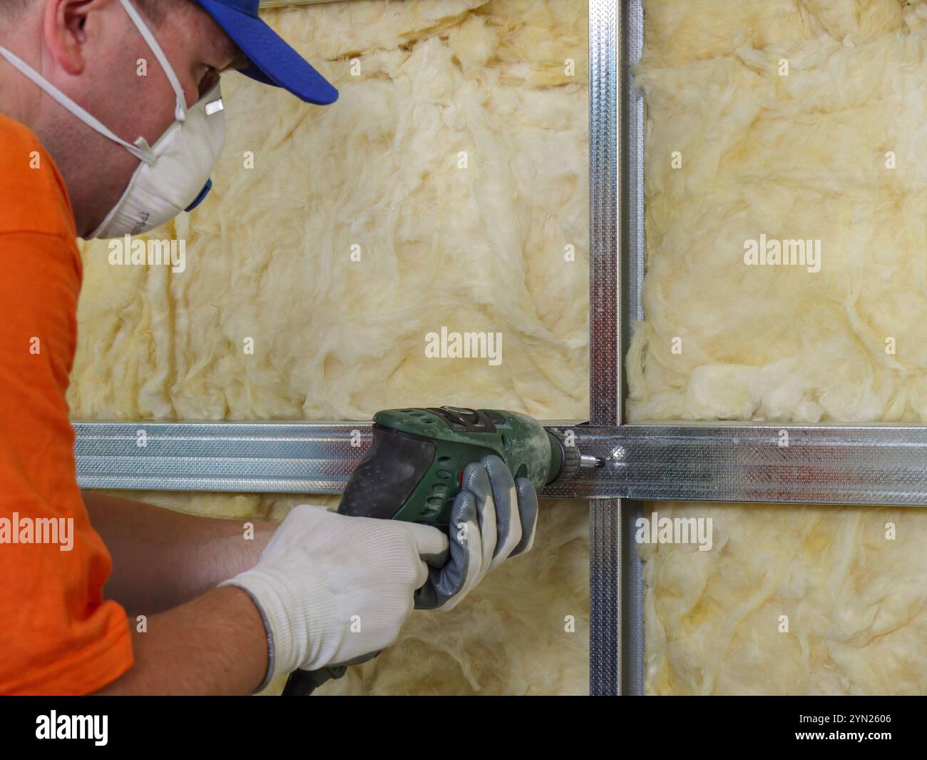 Construction worker thermally insulating house attic with mineral wool ...