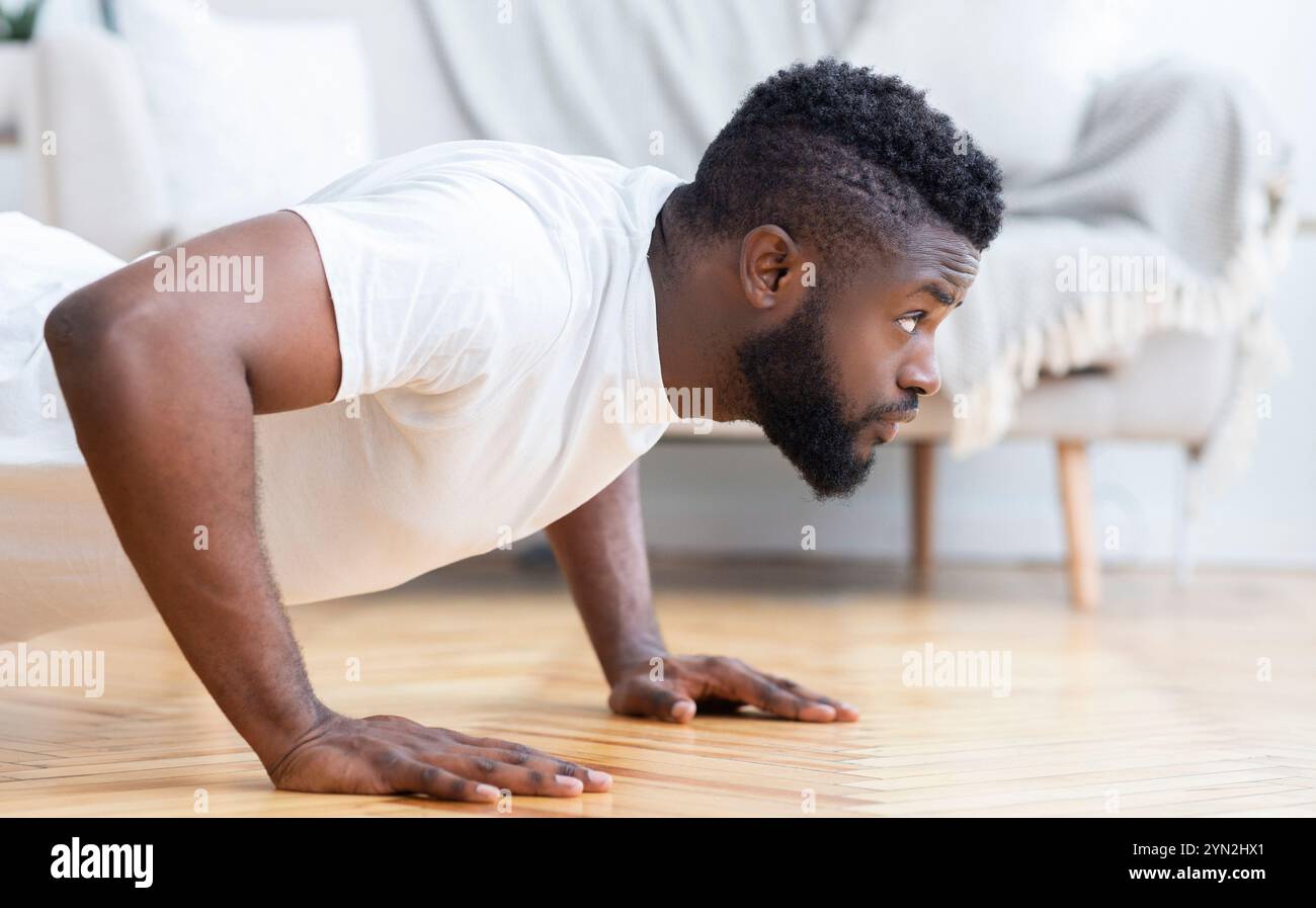Young black man doing push ups, side view Stock Photo