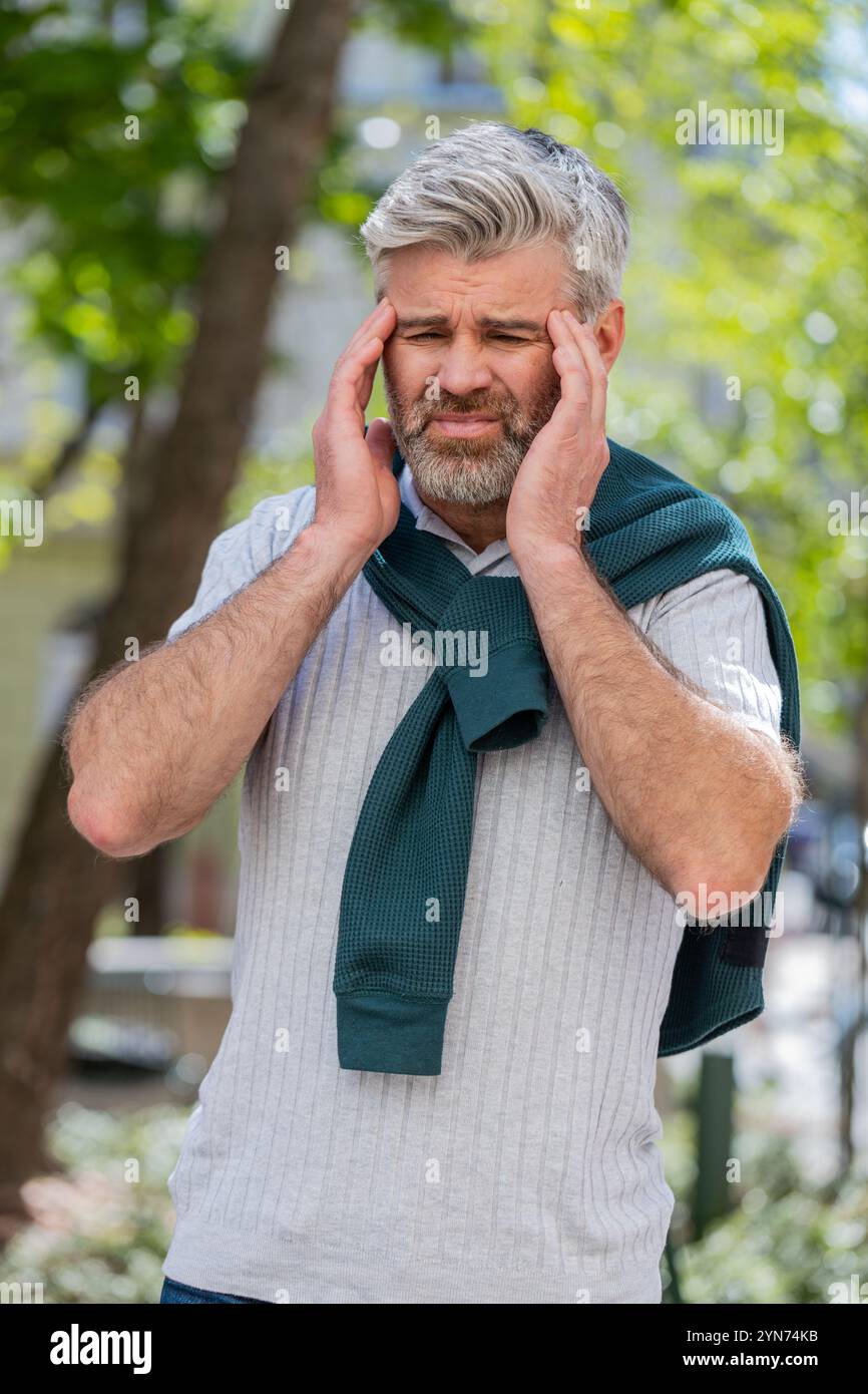 Displeased exhausted Caucasian man rubbing temples to cure headache ...