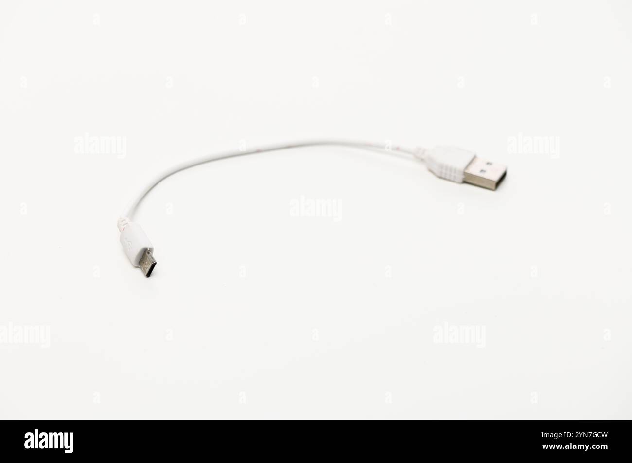 A compact USB cable poised on a clean surface, ready for essential charging and quick data transfer tasks. Stock Photo