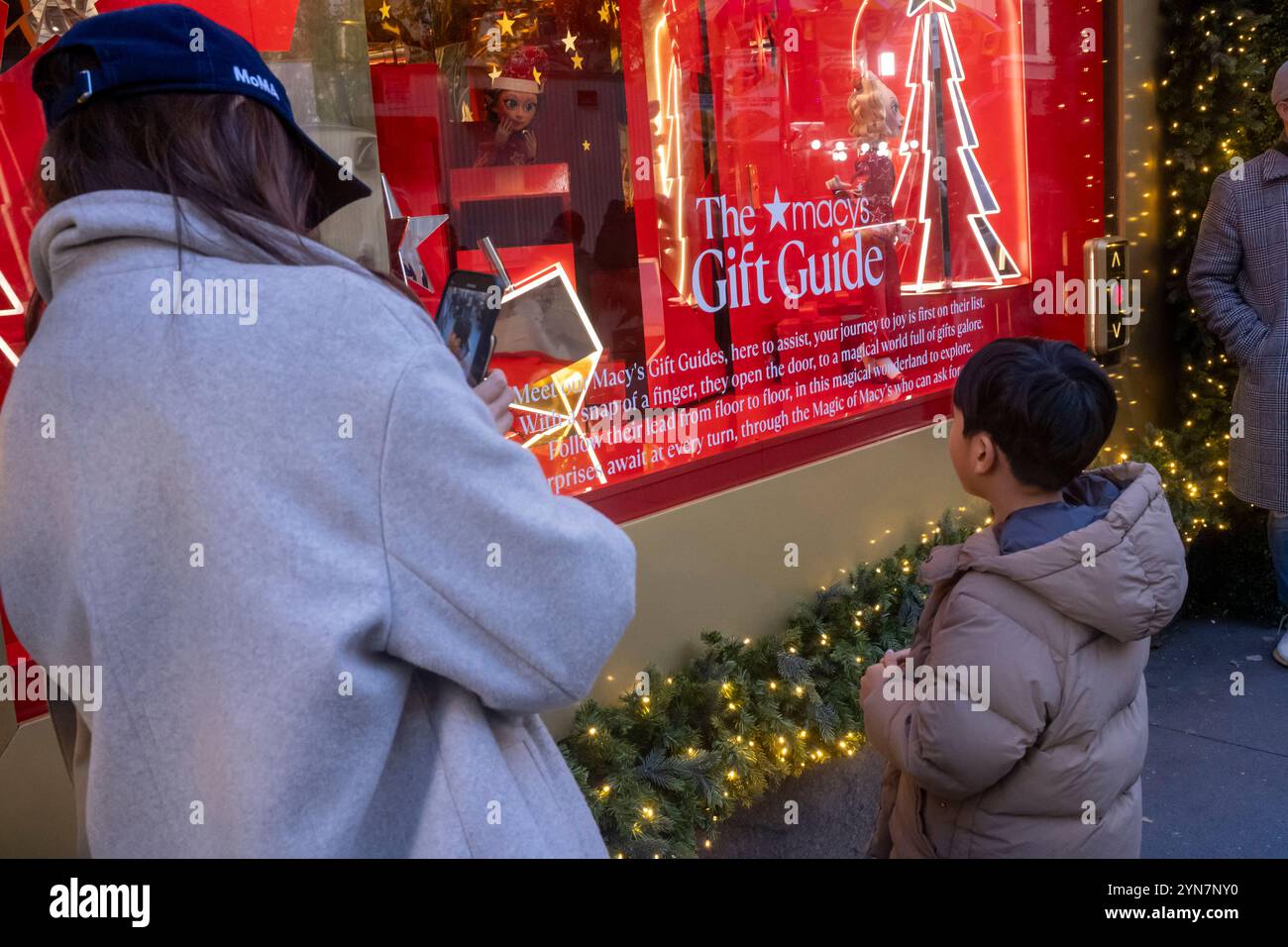 New York, United States. 24th Nov, 2024. NEW YORK, NEW YORK - NOVEMBER 24: A woman and a child look at Macy's holiday window displays at the Macy's Herald Square flagship store on 34th Street in Midtown Manhattan on November 24, 2024 in New York City. Credit: Ron Adar/Alamy Live News Stock Photo