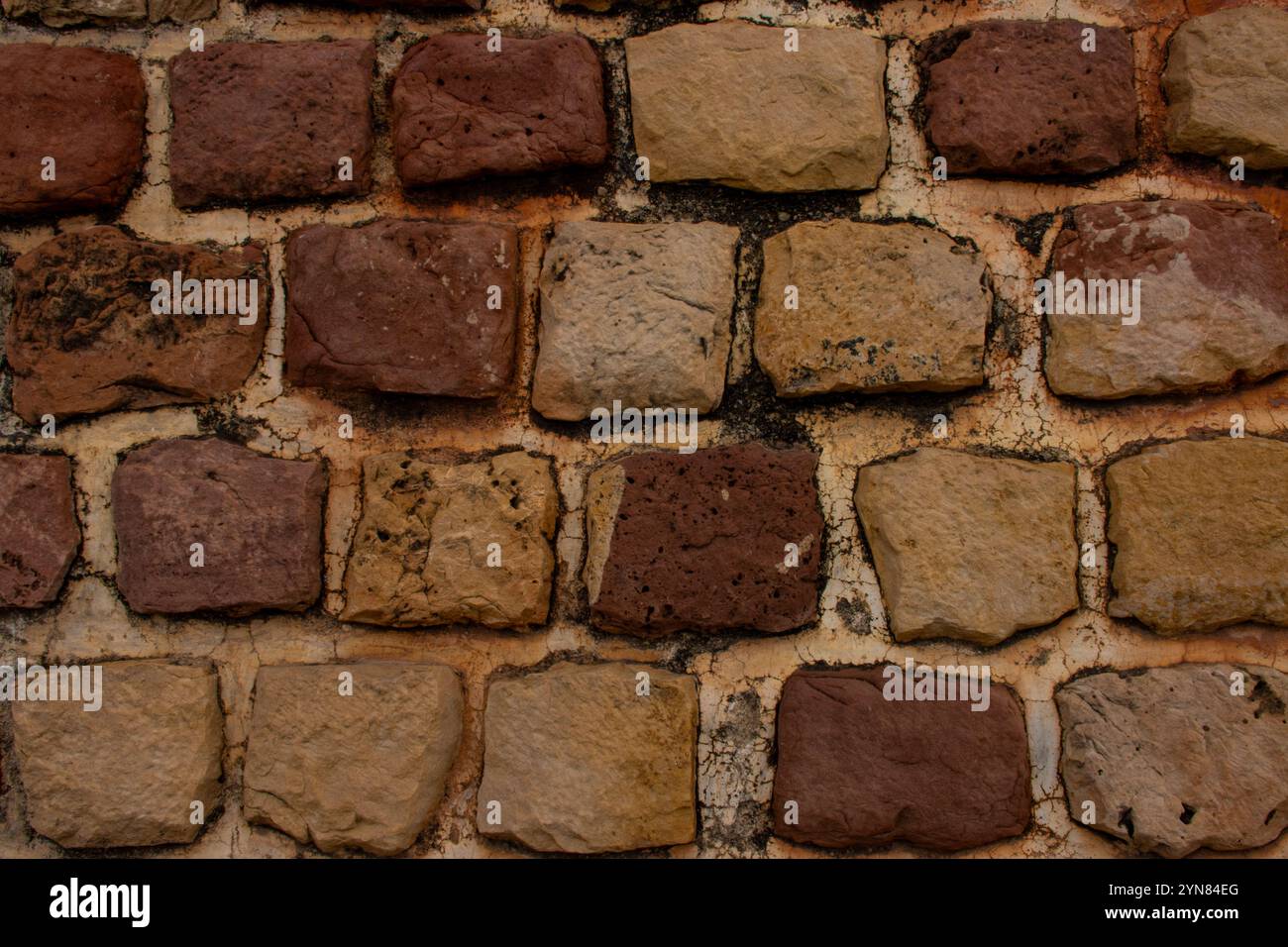 Rustic stone wall texture with warm earthy tones, featuring a mix of ...