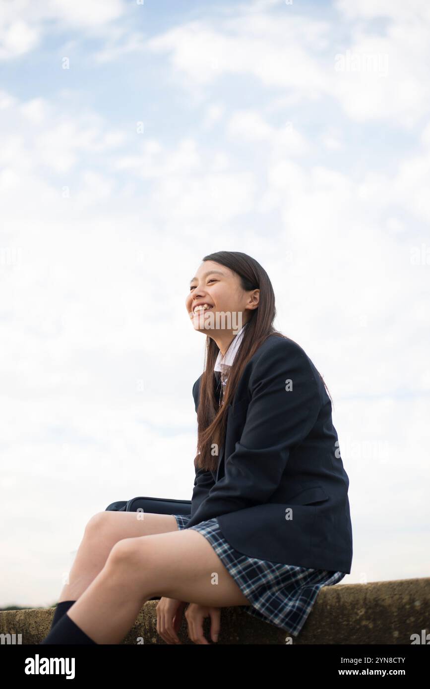 High school girl in school uniform sitting and laughing Stock Photo - Alamy