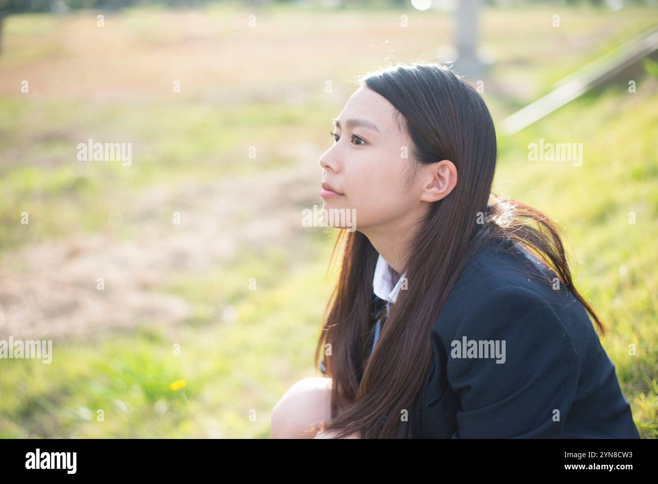 Schoolgirl in school uniform sitting on gymnasium floor Stock Photo - Alamy