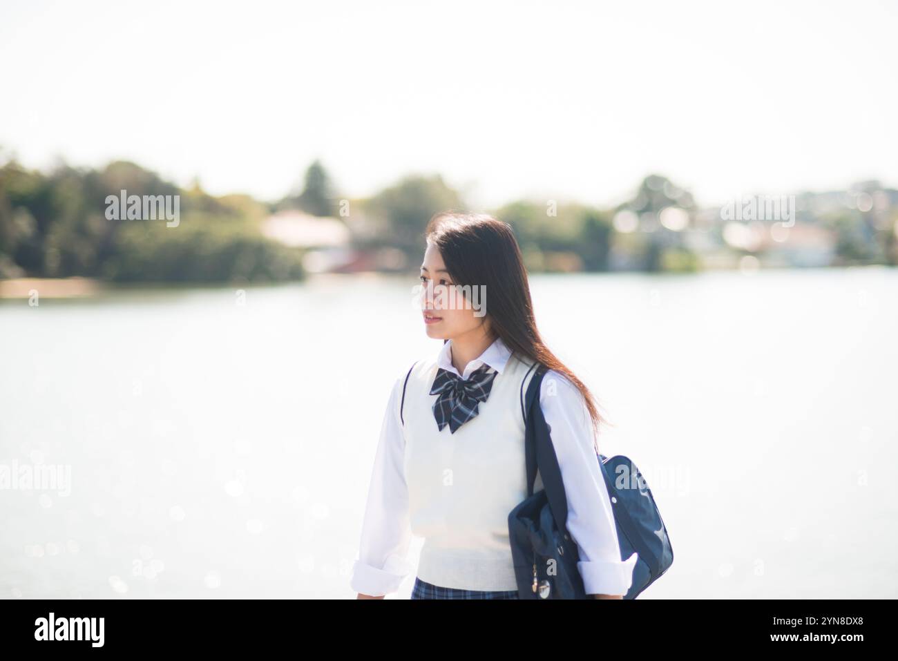 Schoolgirl in uniform walking along waterside Stock Photo - Alamy