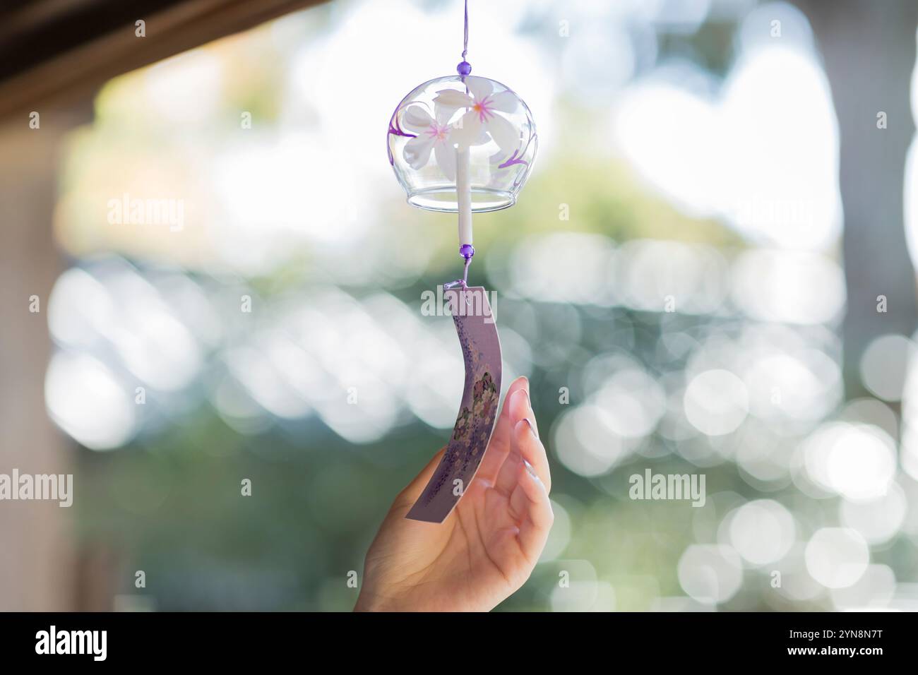 Woman's hand touching wind chime Stock Photo