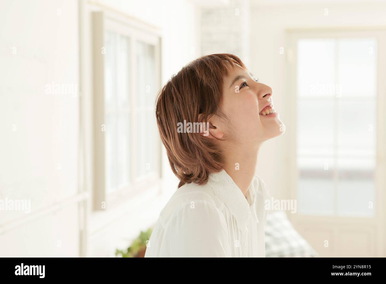Woman in her 20s looking upwards and smiling in profile Stock Photo - Alamy