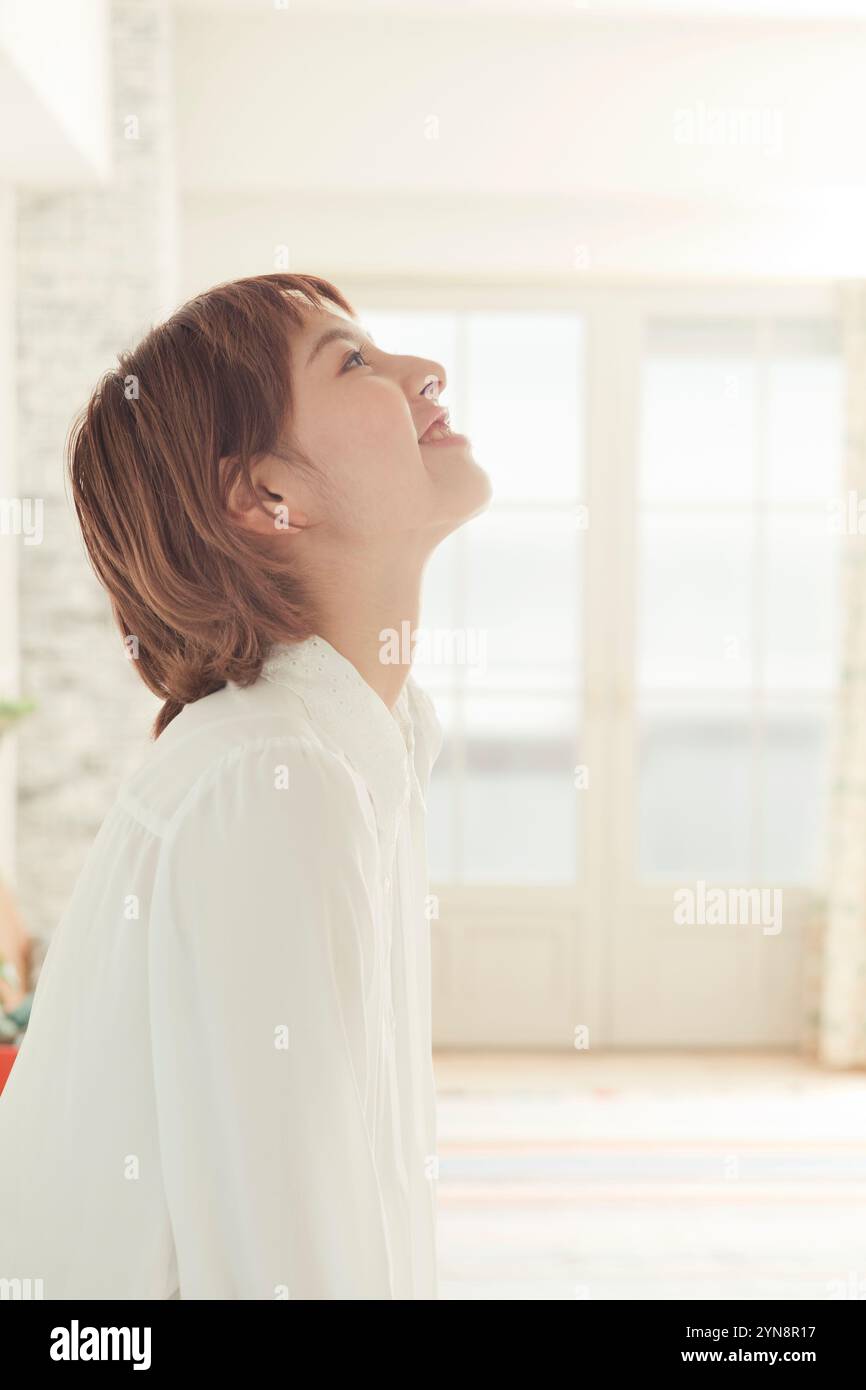 Woman in her 20s looking upwards and smiling in profile Stock Photo - Alamy