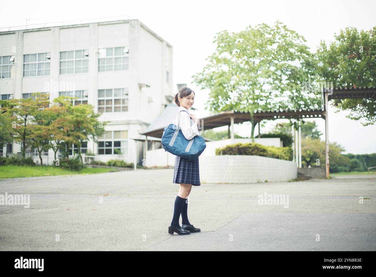 High school girl standing in front of school building Stock Photo - Alamy