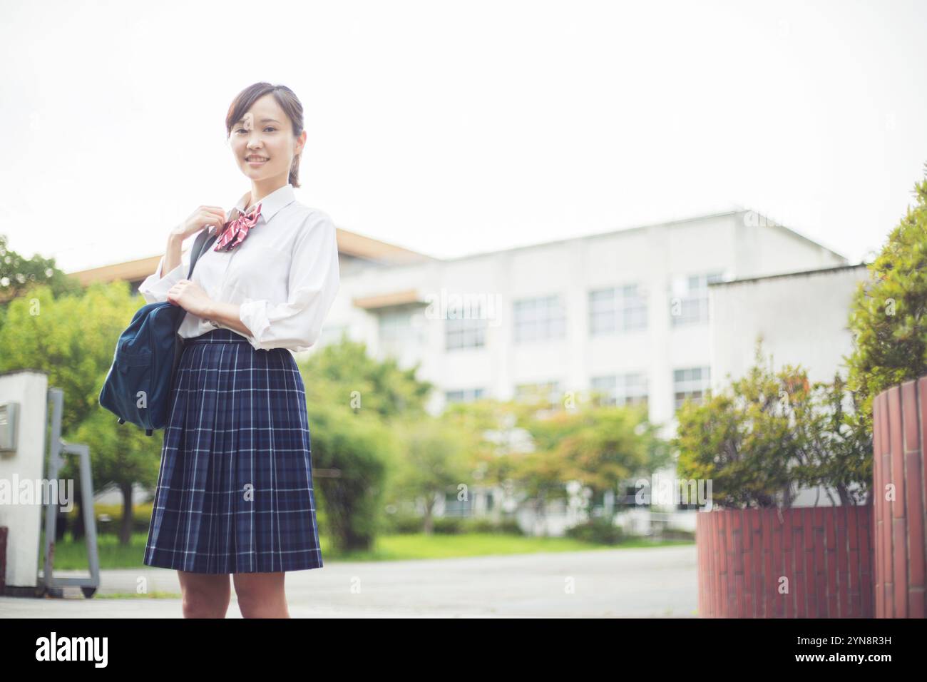High school girl standing in front of the school gate Stock Photo - Alamy