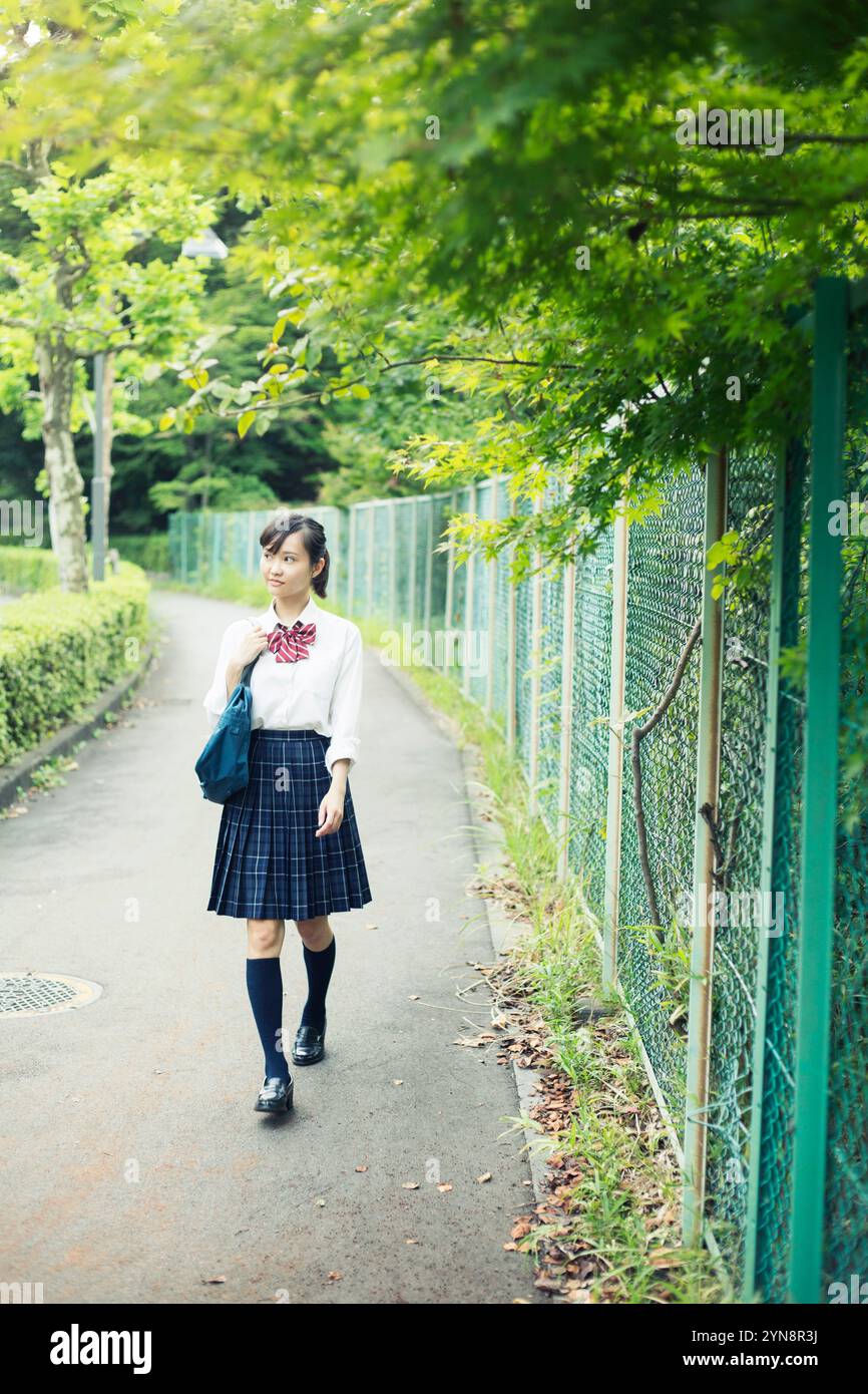 High school girls in uniform walking on the road Stock Photo - Alamy