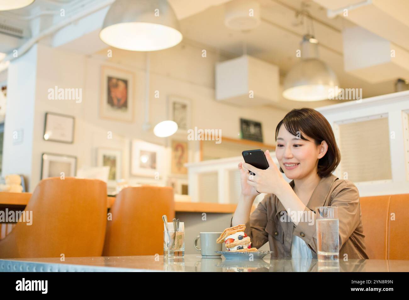 Woman in her 20s taking a picture of a sweet Stock Photo - Alamy