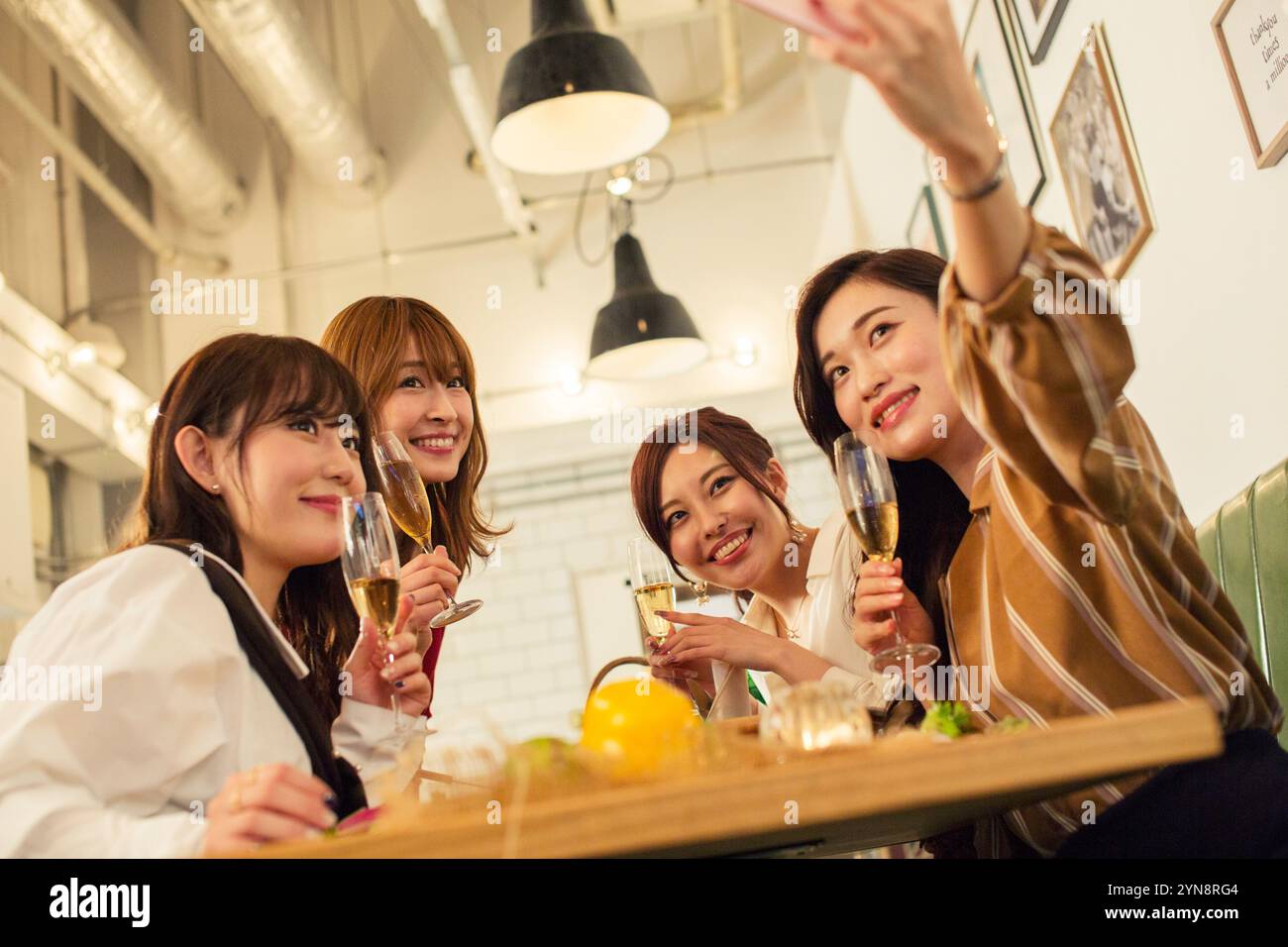 Four women in their 20s enjoying a girls' party Stock Photo - Alamy