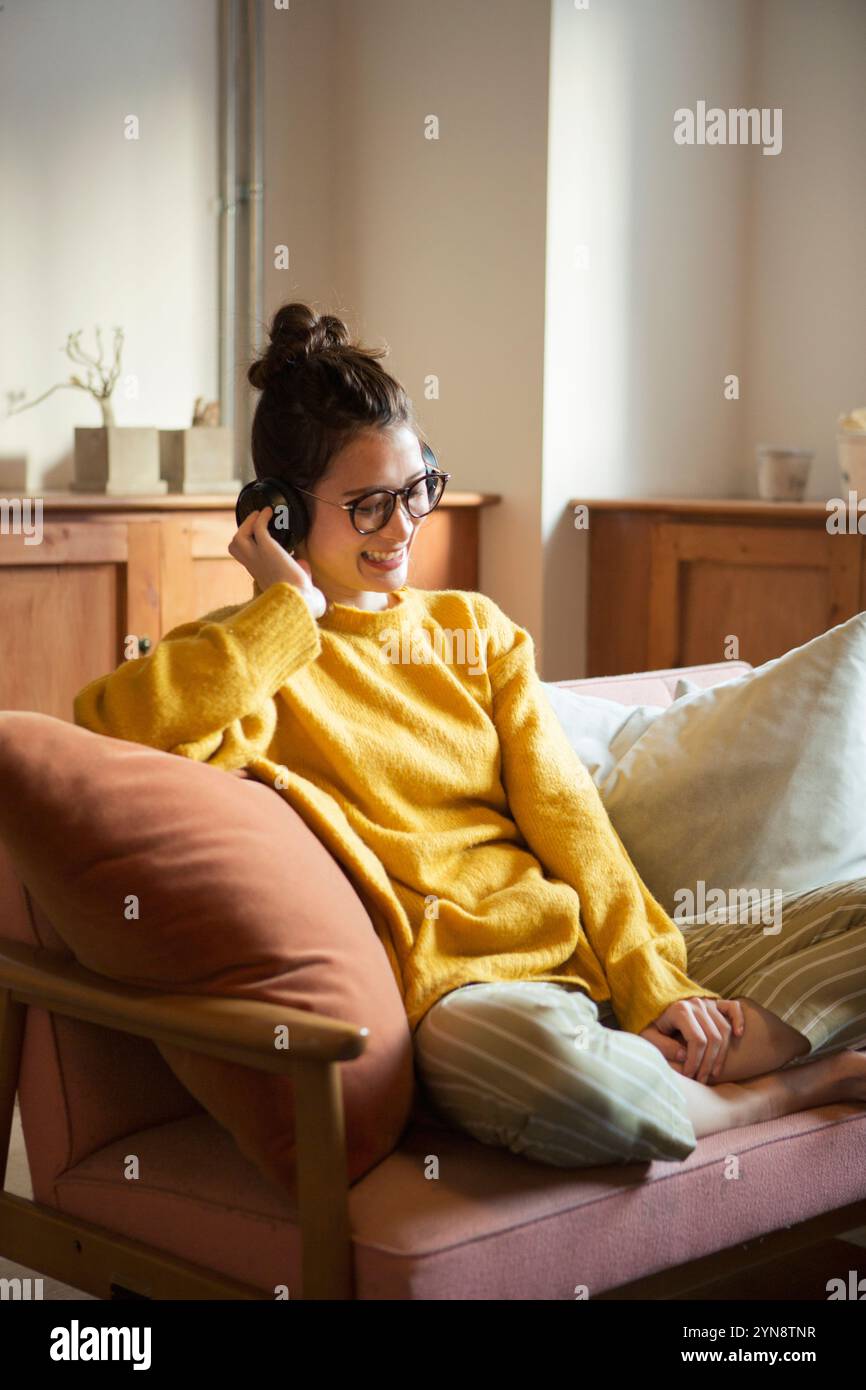 Smiling 20s woman listening to music in her room Stock Photo - Alamy