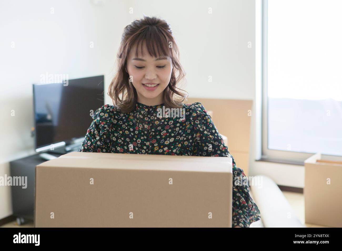 Woman in her 20s carrying a packed parcel Stock Photo - Alamy
