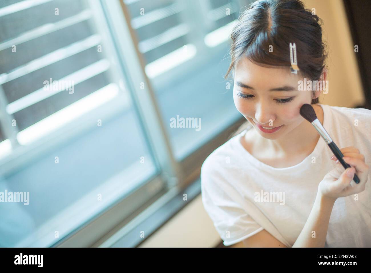 Smiling 20s woman doing her make-up in her room Stock Photo - Alamy