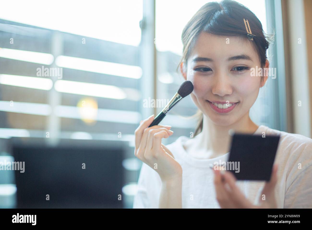 Smiling 20s woman doing her make-up in her room Stock Photo - Alamy