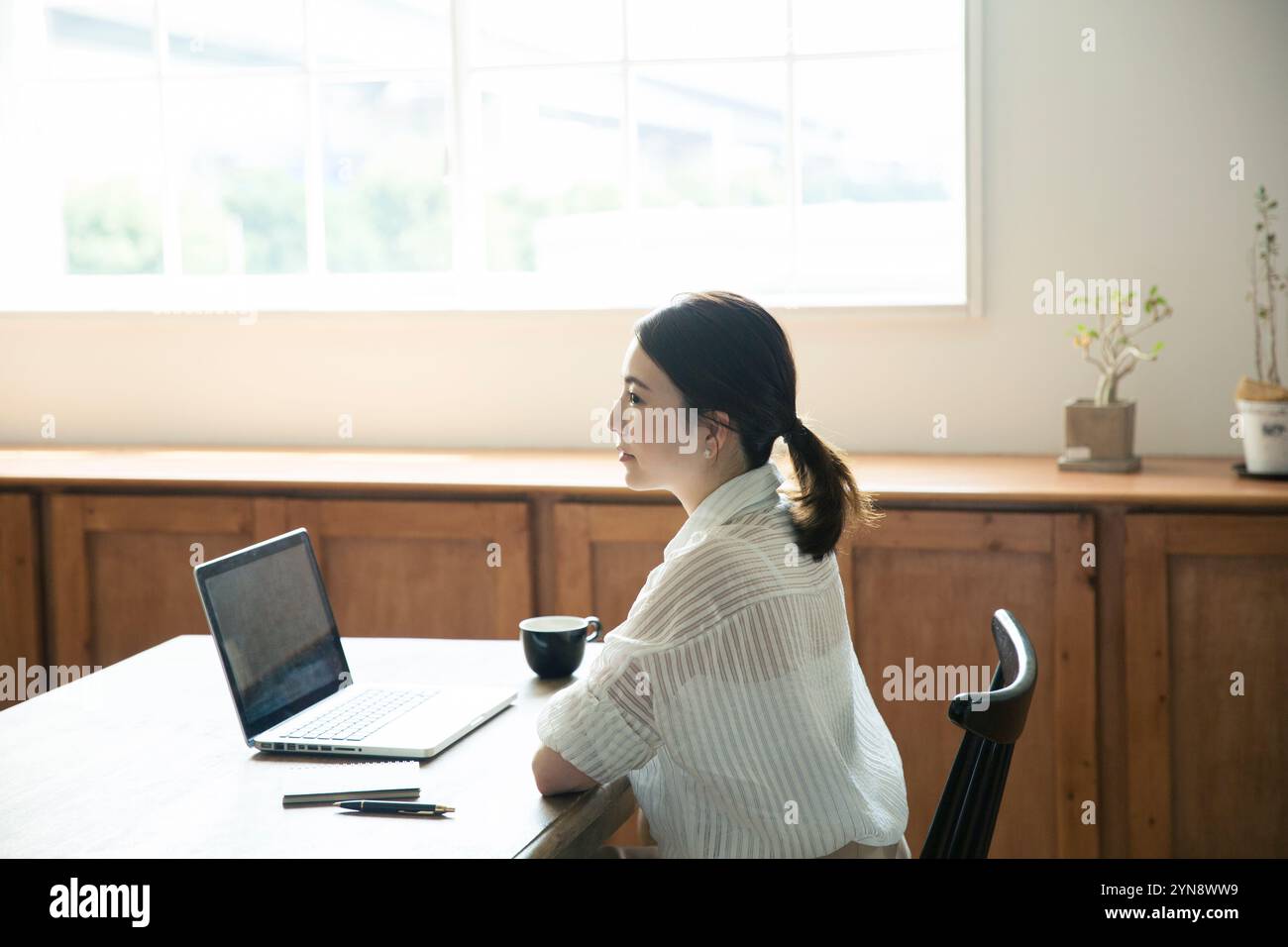 Profile of a woman in her 20s working by the window Stock Photo - Alamy