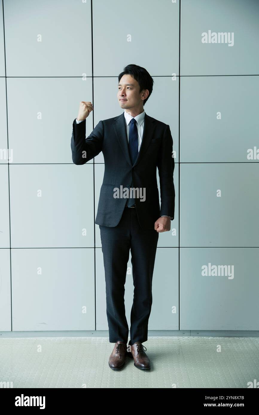 Portrait of a man in his 20s in a suit posing with his guts Stock Photo