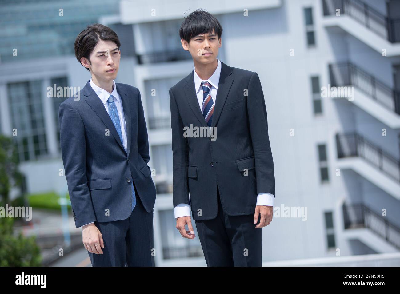 Two men in their 20s in suits standing on the rooftop Stock Photo - Alamy