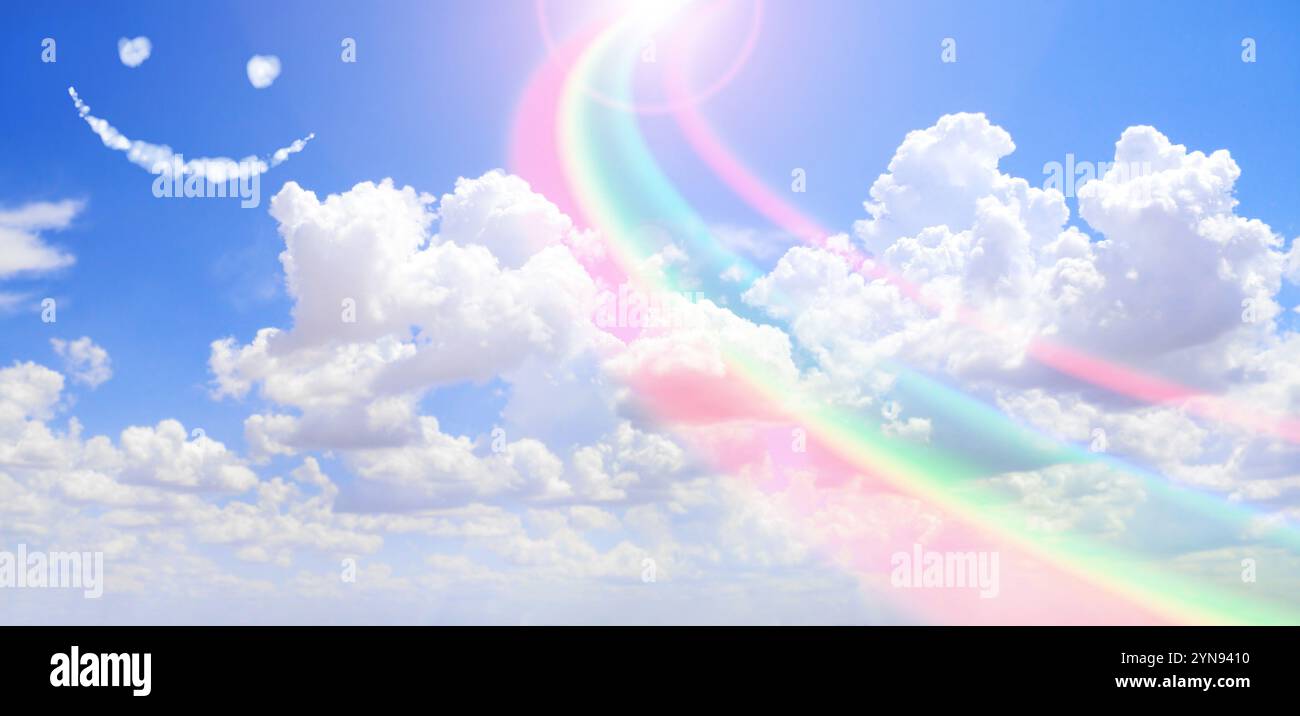 Feeling happy and good mood concept. Horizontal nature banner with blue sky, pretty clouds, rainbow and funny cloud emoji. Rainbow Sky. Fluffy clouds Stock Photo