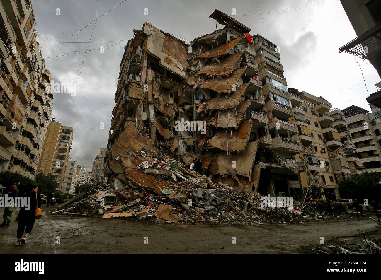 Devastated Building 25 November 2024, Lebanon, Beirut: A woman passes by a devastated ...