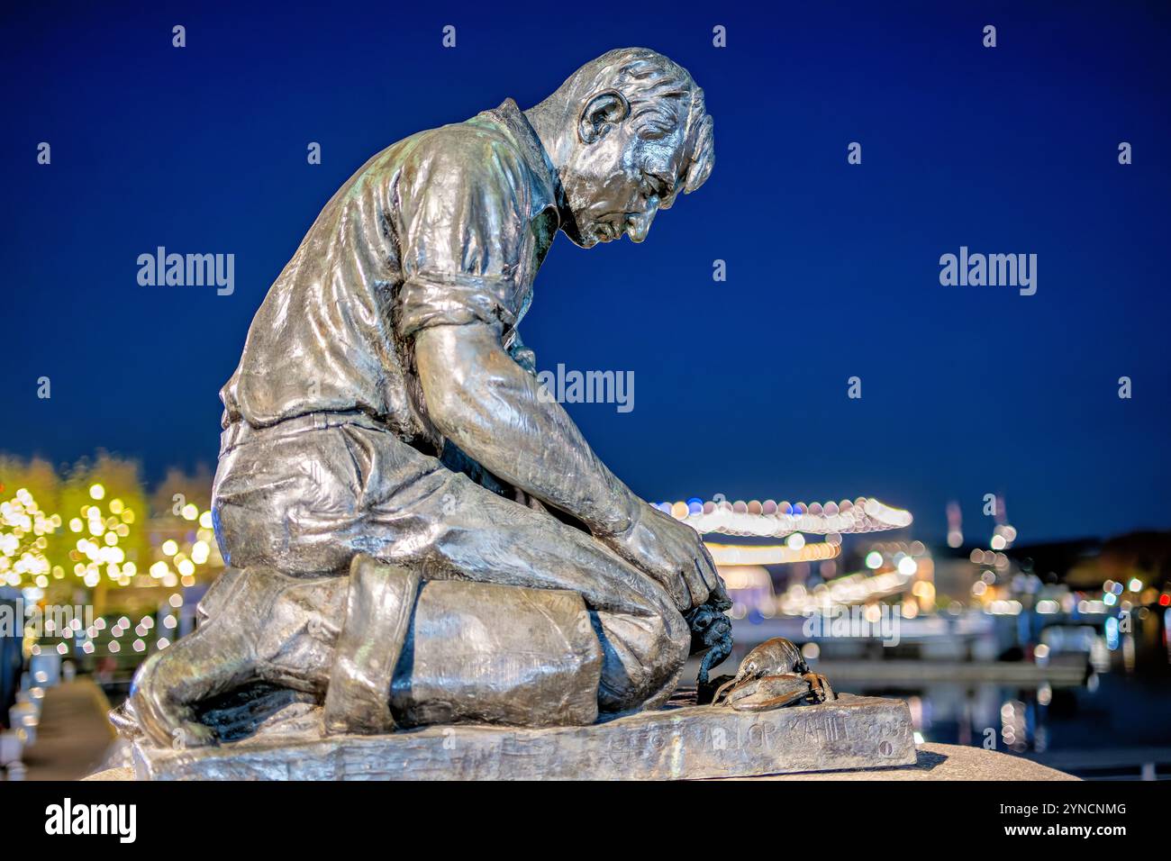 WASHINGTON DC, United States — A replica of Victor Kahill's Maine Lobsterman statue stands at The Wharf in Southwest DC. The original 1939 bronze sculpture depicts Bailey Island fisherman H. Bailey Wilbert in his oil clothes, demonstrating the traditional method of pegging lobster claws. Another casting of the statue stands in Portland, Maine. Stock Photo