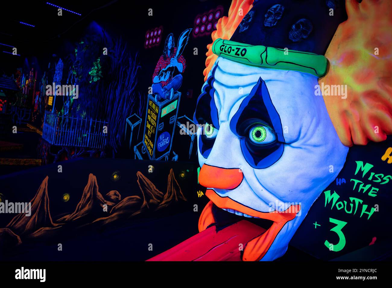 Monster Mini Golf Interior Chantilly Virginia // CHANTILLY, Virginia — The interior of Monster Mini Golf features vibrant UV-reactive decorations and neon artwork illuminated by blacklights throughout the indoor mini golf course. The facility combines monster-themed elements with fluorescent colors to create an immersive glow-in-the-dark putting experience. Stock Photo