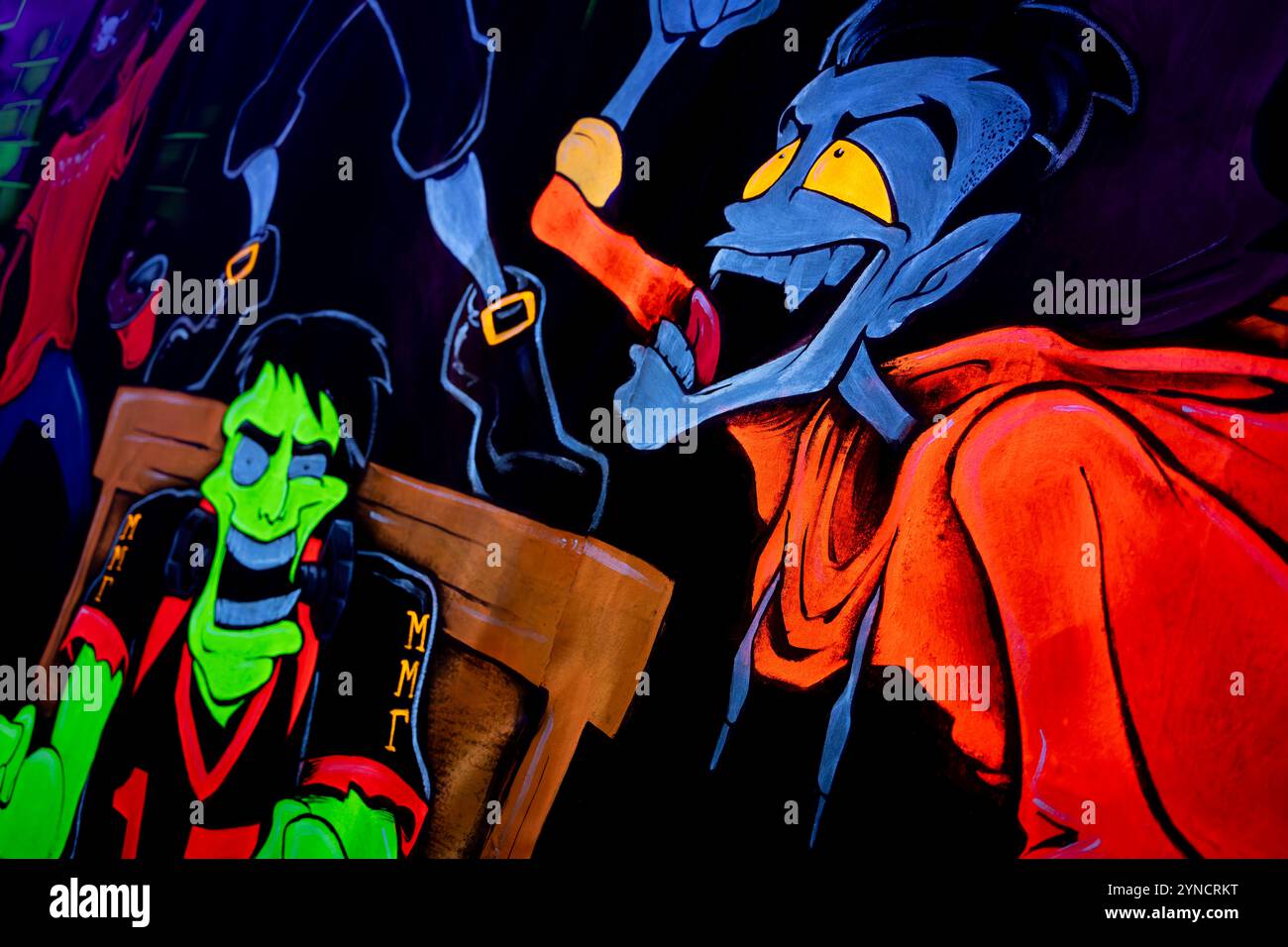 Monster Mini Golf Interior Chantilly Virginia // CHANTILLY, Virginia — The interior of Monster Mini Golf features vibrant UV-reactive decorations and neon artwork illuminated by blacklights throughout the indoor mini golf course. The facility combines monster-themed elements with fluorescent colors to create an immersive glow-in-the-dark putting experience. Stock Photo