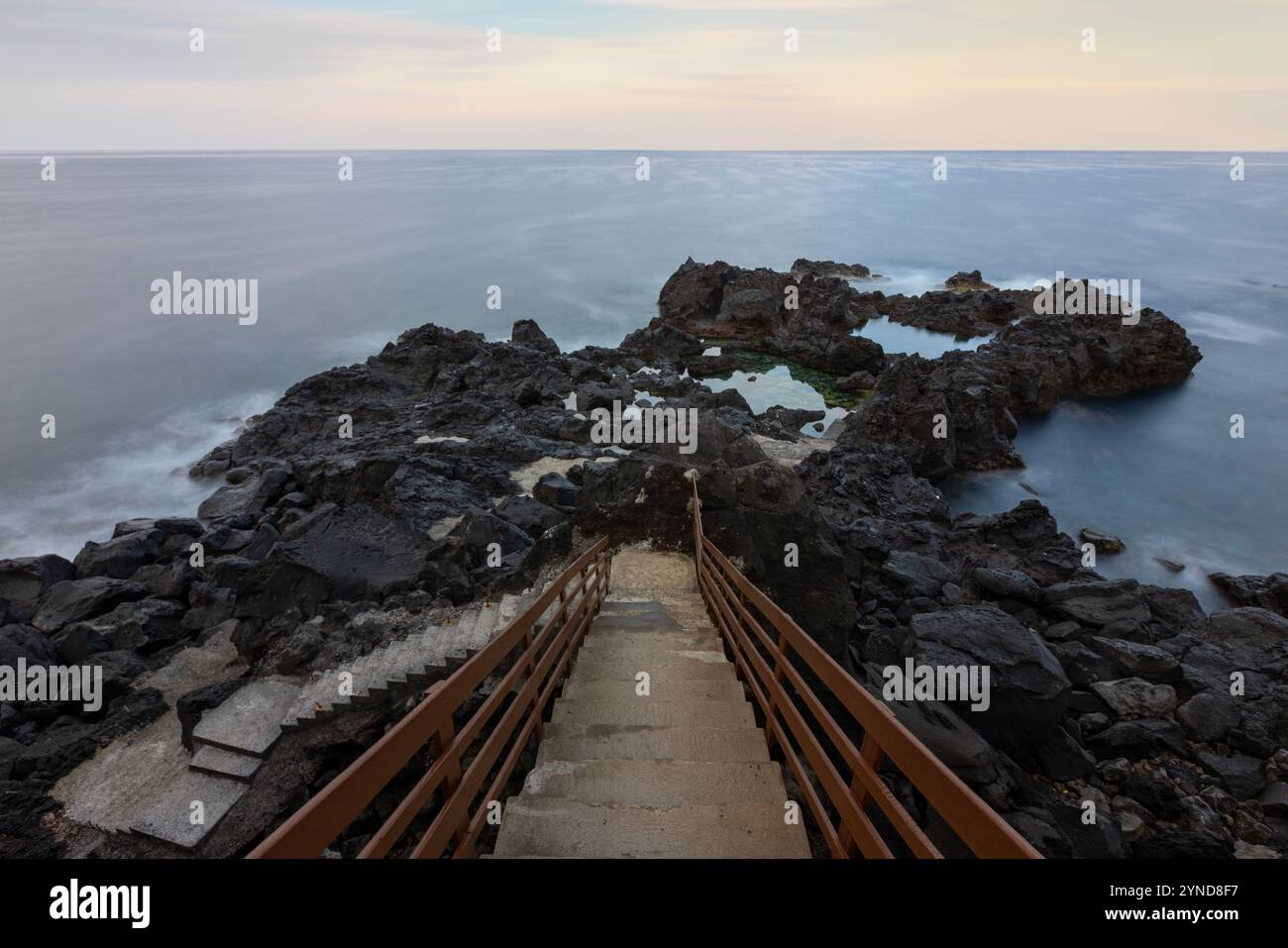 The Poceirões Natural Pools are on the island of Graciosa Azores, featuring lava pools and a restored traditional windmill. Stock Photo