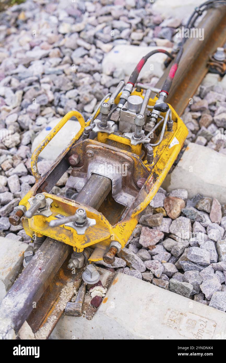 Yellow technical device on the tracks, surrounded by stone ballast ...
