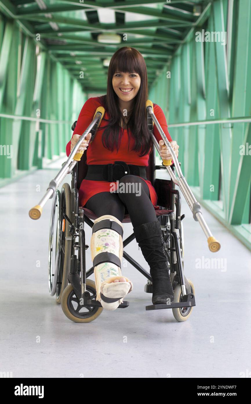 Dark-haired woman with plaster leg sitting in wheelchair, 35 years old, hospital, Hospital Vienna, Austria, Europe Stock Photo