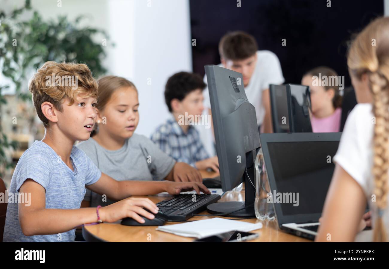 Computer science lesson in a school computer class - a girl and a boy ...