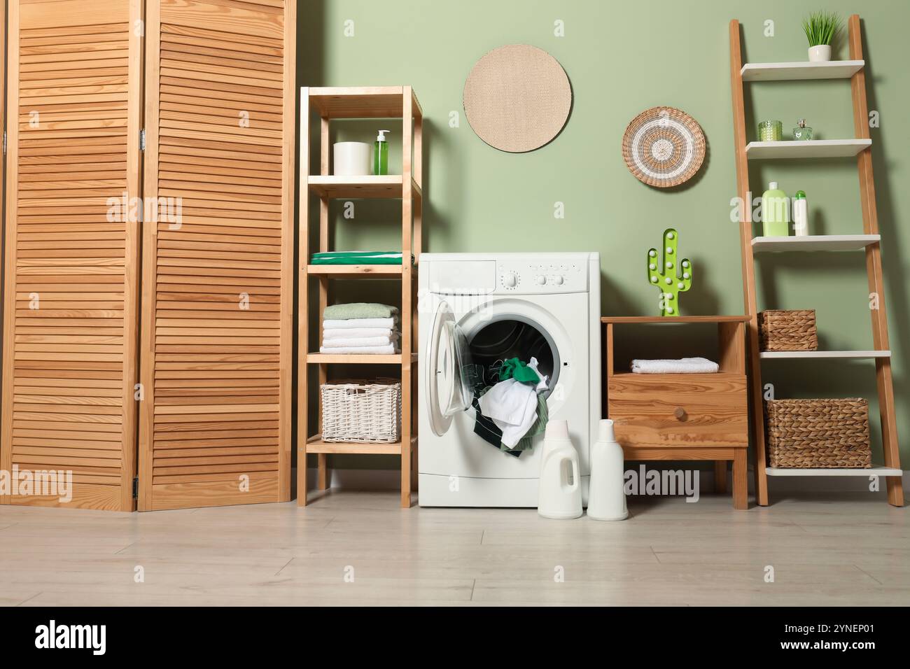 Washing machine, detergents and towels in room Stock Photo - Alamy