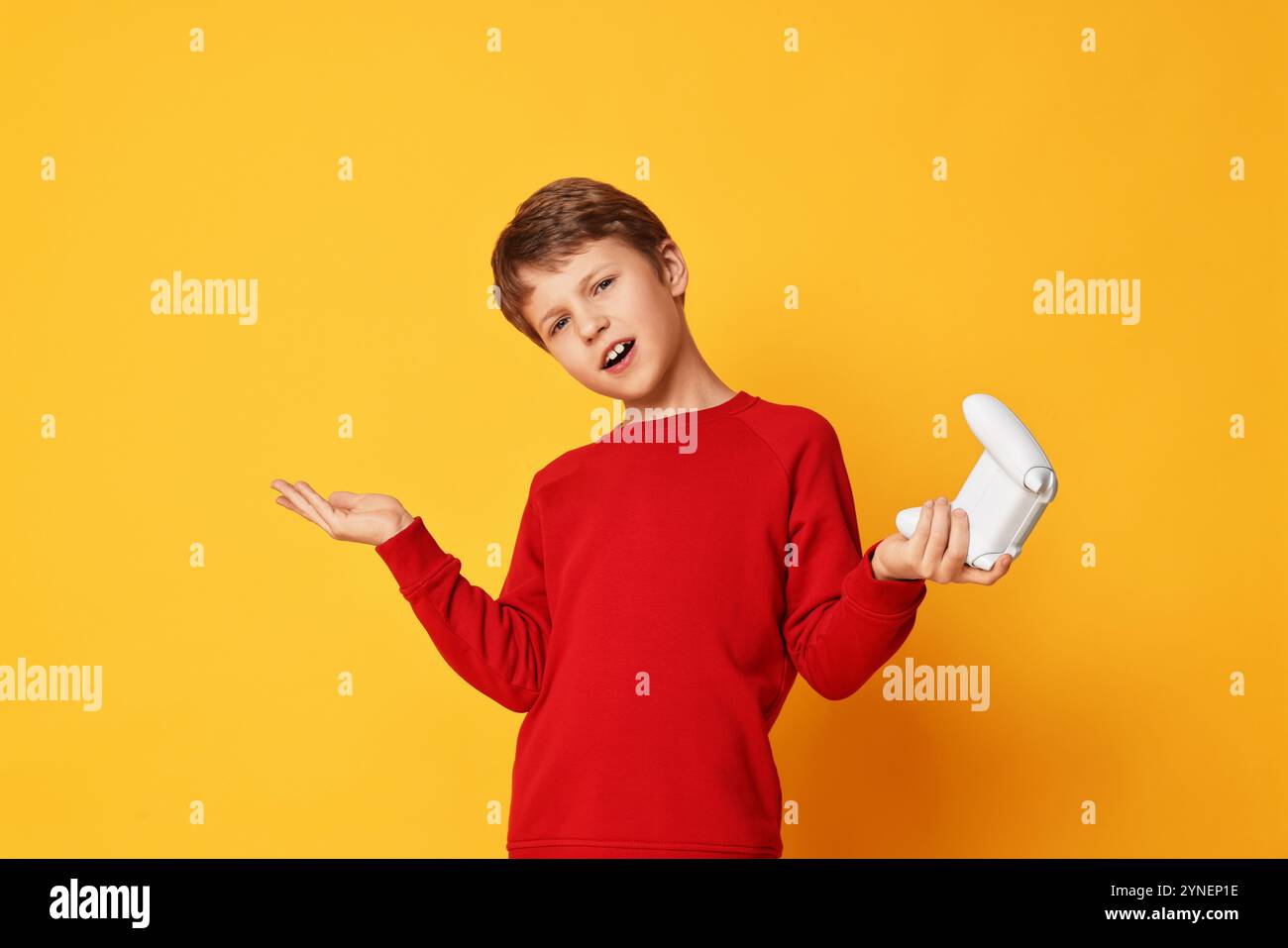 Cute little boy with controller on orange background Stock Photo - Alamy