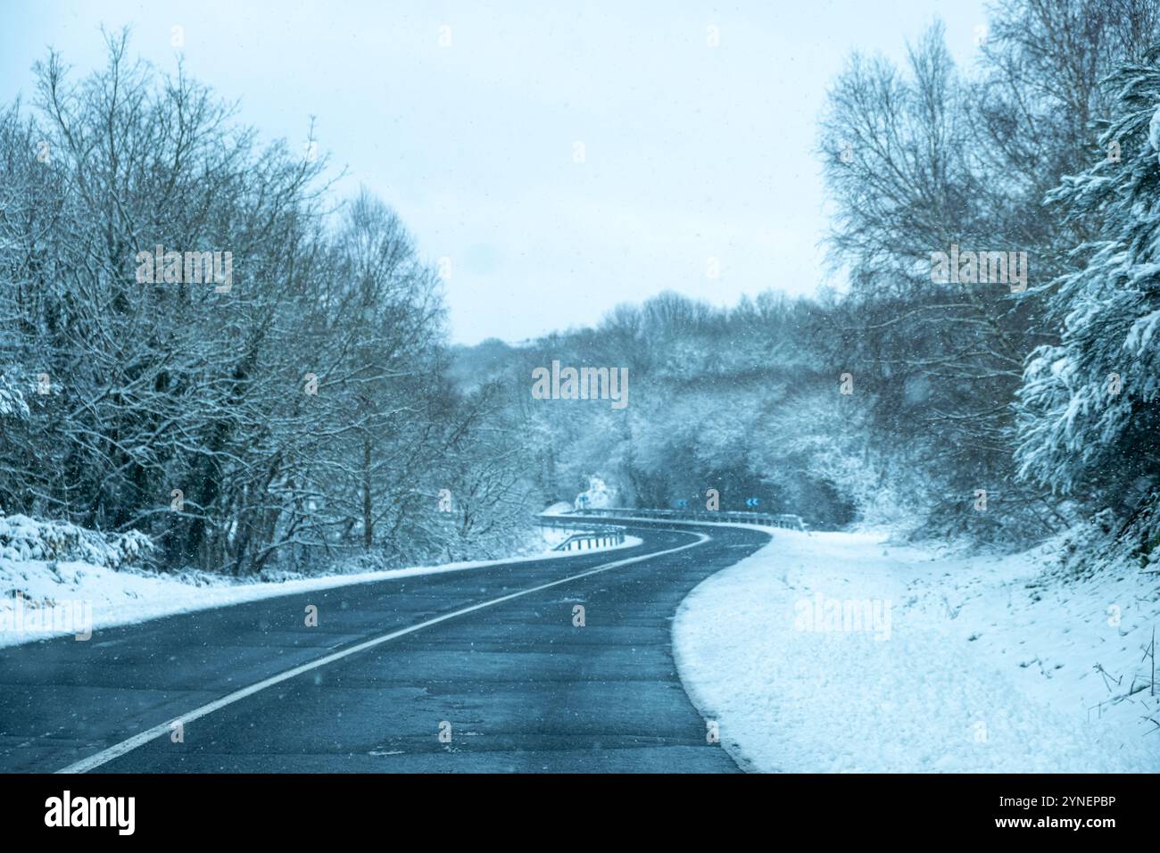 view of a snowy road curve in an icy winter landscape, wintertime ...