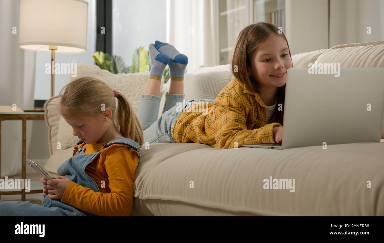 Two Caucasian kids girls sisters daughters friends using different ...